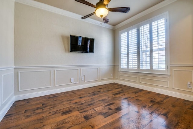 unfurnished room with ceiling fan, a wainscoted wall, ornamental molding, dark wood-style floors, and a decorative wall