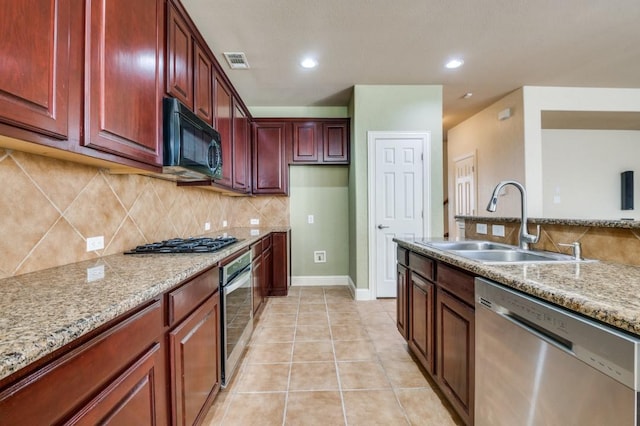 kitchen with light tile patterned floors, visible vents, a sink, stainless steel appliances, and backsplash