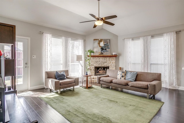 living area featuring lofted ceiling, a fireplace, dark wood-style flooring, and a ceiling fan