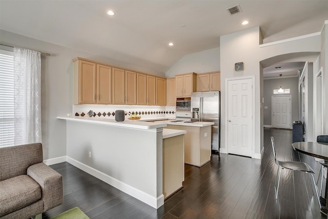 kitchen featuring light brown cabinetry, visible vents, appliances with stainless steel finishes, and arched walkways