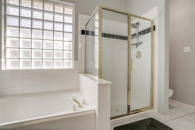 full bath with toilet, a shower stall, a garden tub, and tile patterned flooring