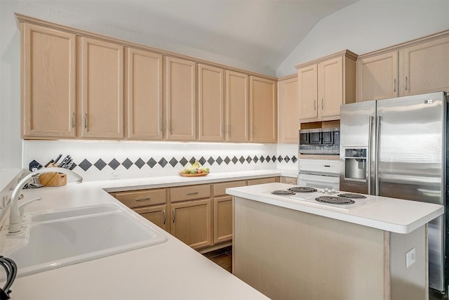 kitchen with a sink, stainless steel appliances, light brown cabinets, and vaulted ceiling