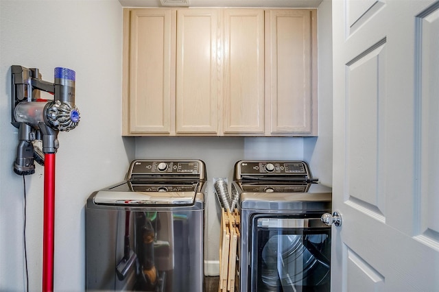 clothes washing area with cabinet space and washing machine and dryer