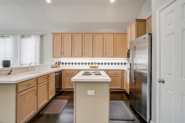 kitchen with a kitchen island, light brown cabinets, stainless steel appliances, and a sink