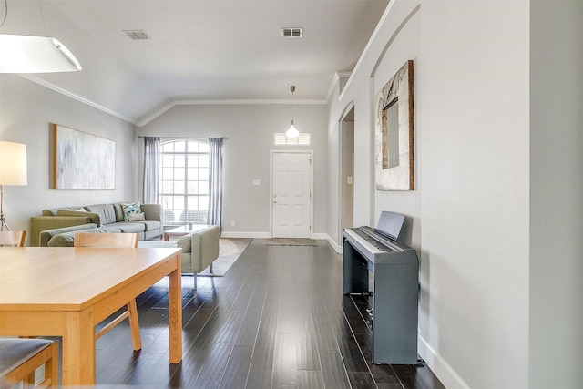 living area with dark wood finished floors, visible vents, baseboards, and ornamental molding