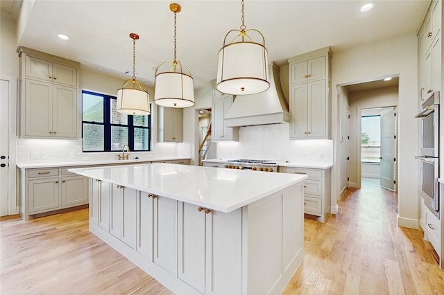 2031 Meadowlark Ct, Aledo, TX 76008 - kitchen with a kitchen island, light countertops, recessed lighting, backsplash, and light wood-style flooring