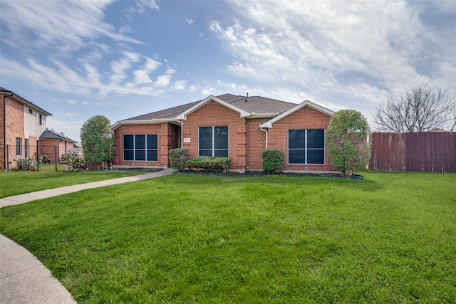 ranch-style home featuring brick siding, a front lawn, and fence