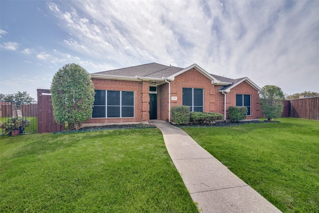 single story home featuring a front lawn, fence, and brick siding