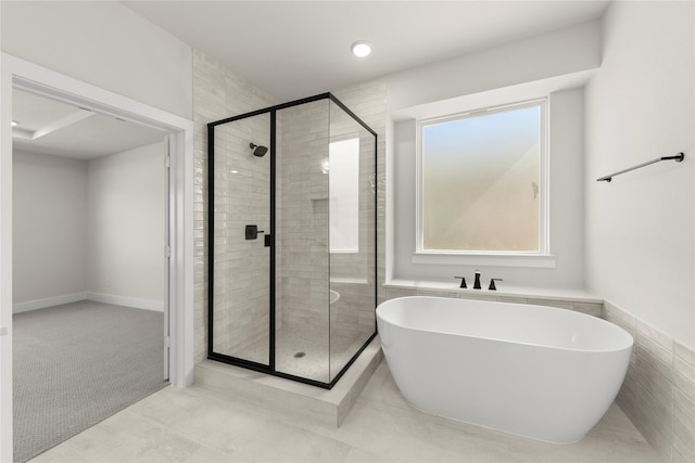 full bathroom with a shower stall and a freestanding tub