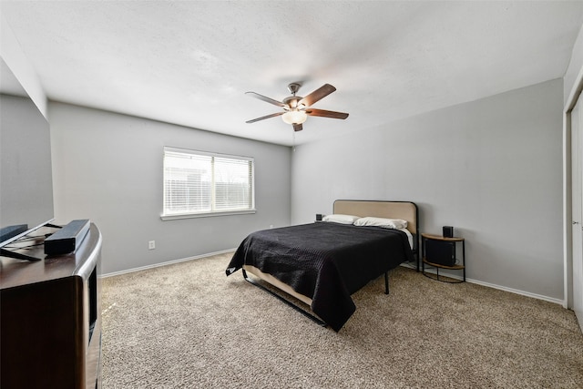 carpeted bedroom with a ceiling fan, baseboards, and a textured ceiling