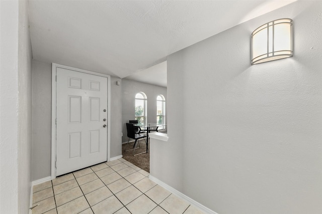 foyer featuring light tile patterned floors and baseboards