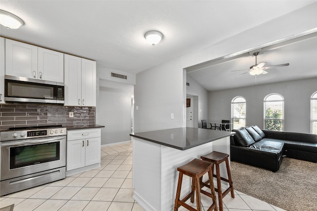 kitchen featuring light tile patterned floors, visible vents, a breakfast bar, appliances with stainless steel finishes, and open floor plan