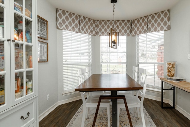 dining space with baseboards and dark wood finished floors