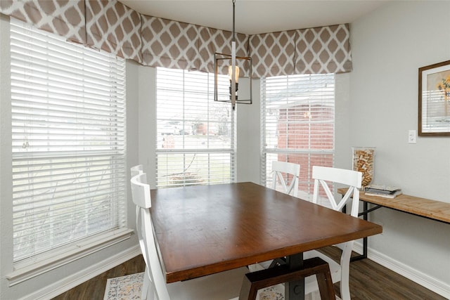 dining area with baseboards, an inviting chandelier, and dark wood-style flooring