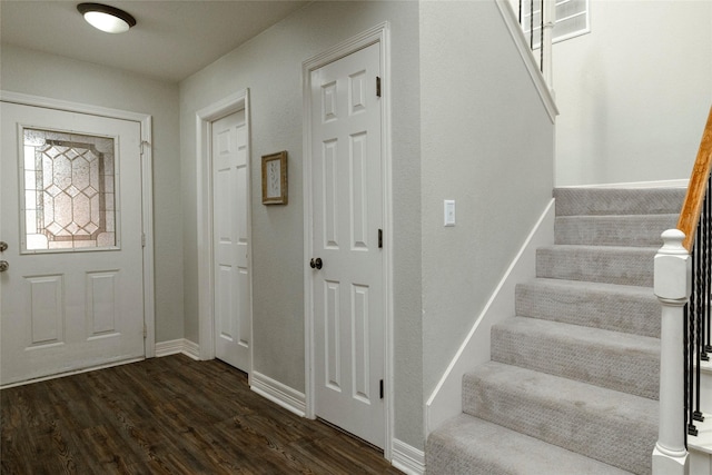 foyer with stairway, baseboards, and dark wood-style flooring