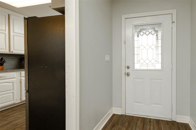 doorway with baseboards and dark wood-style flooring