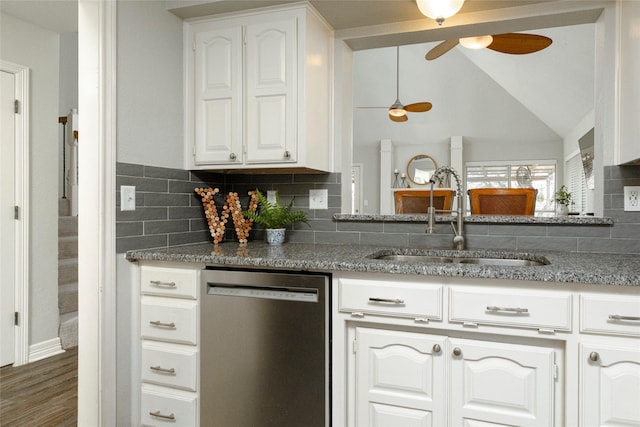 kitchen with white cabinetry, ceiling fan, a sink, stainless steel dishwasher, and backsplash