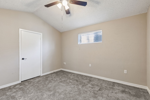 carpeted empty room featuring baseboards, a textured ceiling, a ceiling fan, and vaulted ceiling