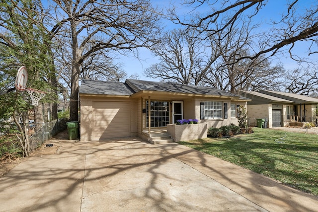 view of front facade with brick siding, a front lawn, fence, concrete driveway, and an attached garage