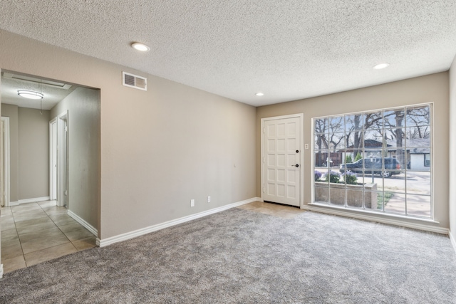 tiled spare room with visible vents, recessed lighting, carpet flooring, baseboards, and attic access