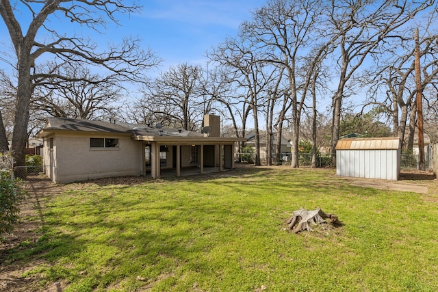 view of yard featuring a storage unit, a fenced backyard, and an outdoor structure