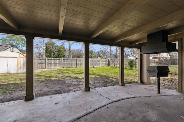 view of patio with an outdoor structure, a fenced backyard, and a shed