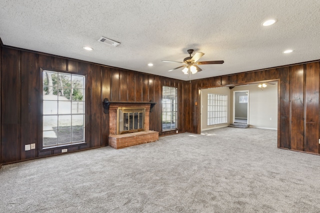 unfurnished living room with carpet flooring, a healthy amount of sunlight, and ceiling fan