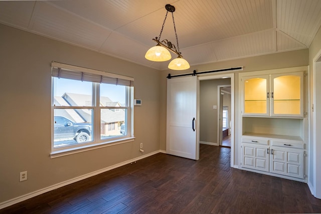 interior space featuring a barn door, lofted ceiling, dark wood-type flooring, and baseboards