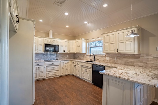 kitchen featuring visible vents, lofted ceiling, a peninsula, black appliances, and a sink