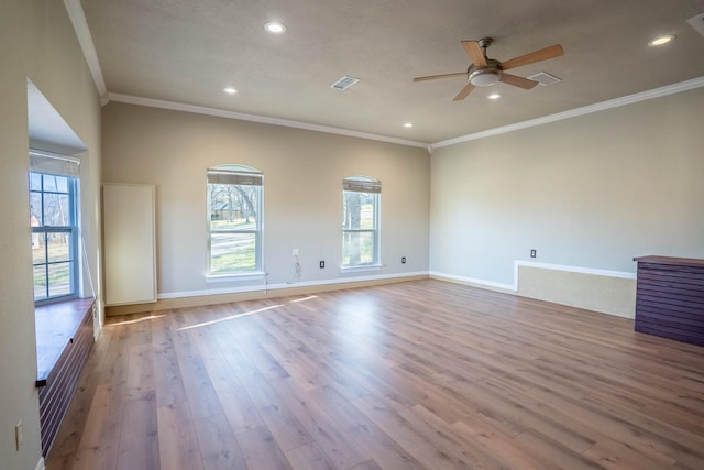 empty room with visible vents, plenty of natural light, ceiling fan, and wood finished floors