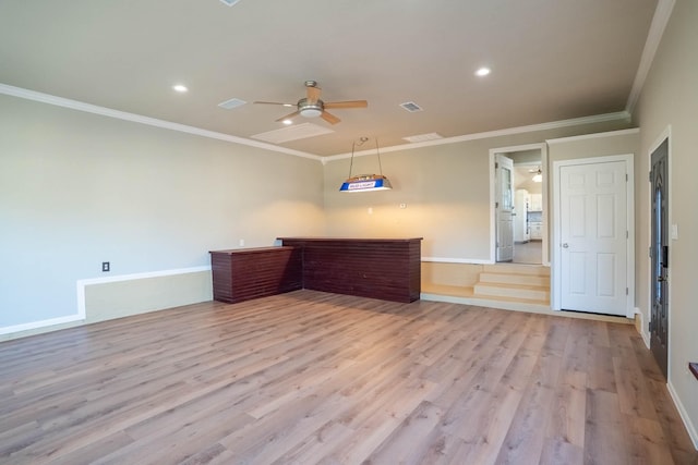 interior space with visible vents, baseboards, wood finished floors, and ornamental molding