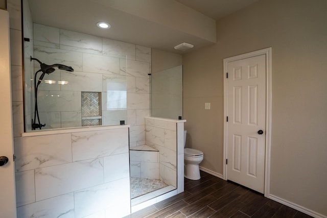 bathroom with baseboards, wood tiled floor, recessed lighting, a walk in shower, and toilet