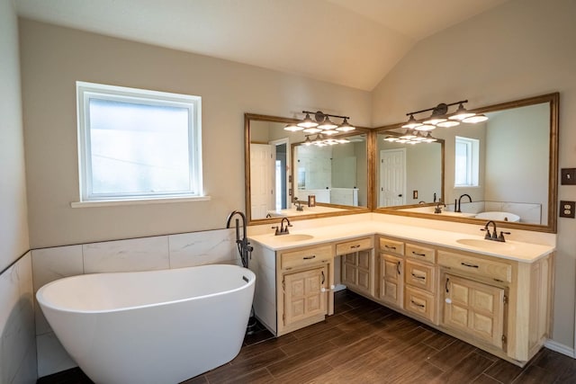 full bathroom featuring a sink, a soaking tub, wood tiled floor, and vaulted ceiling