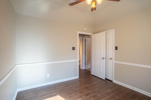 unfurnished room featuring a ceiling fan, dark wood-style flooring, and baseboards