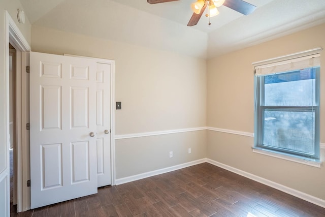 empty room with vaulted ceiling, baseboards, ceiling fan, and dark wood-style flooring