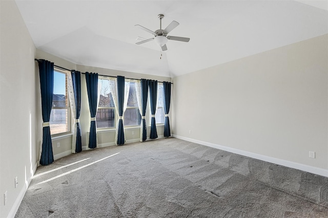 spare room with carpet flooring, baseboards, a ceiling fan, and vaulted ceiling