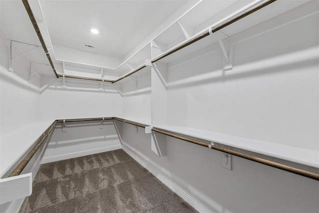 walk in closet with visible vents and dark colored carpet