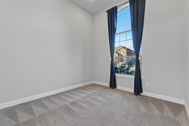 empty room featuring baseboards and carpet floors