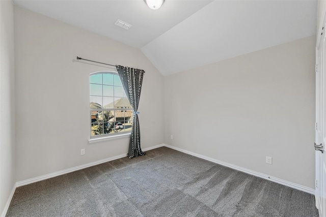 carpeted spare room with visible vents, baseboards, and vaulted ceiling