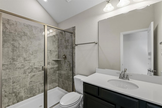 bathroom featuring lofted ceiling, toilet, a stall shower, and vanity