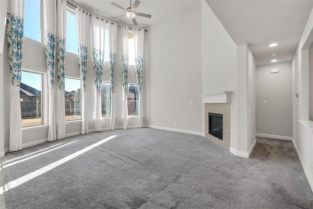 unfurnished living room with carpet, baseboards, recessed lighting, a tile fireplace, and ceiling fan