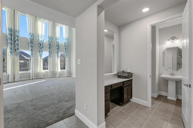 bathroom featuring tile patterned flooring, recessed lighting, baseboards, and a sink