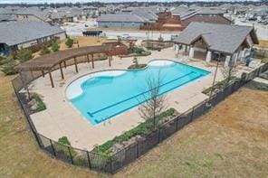 community pool with a patio and fence