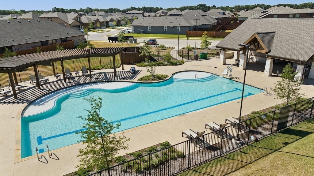 pool with a patio, fence, a residential view, and a pergola