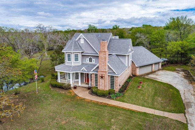 view of front of home with a garage, a porch, a front yard, and roof with shingles