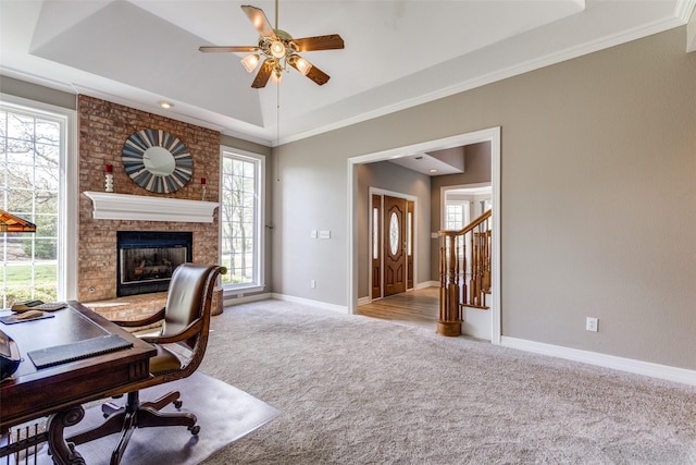 home office with ceiling fan, baseboards, a tray ceiling, and carpet