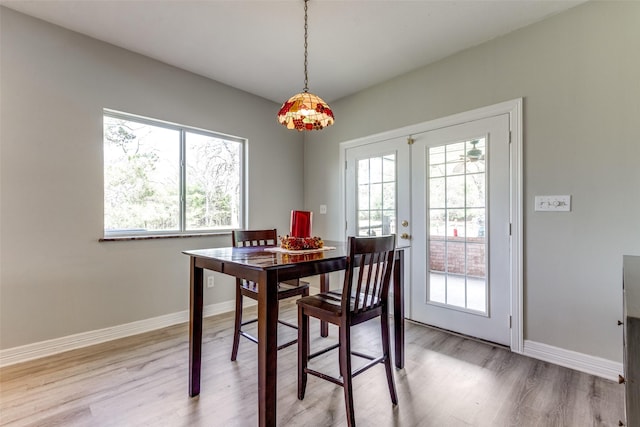 dining space featuring plenty of natural light, french doors, and light wood finished floors