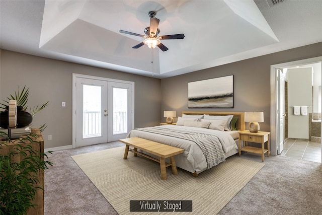 bedroom featuring a tray ceiling, light colored carpet, and access to exterior