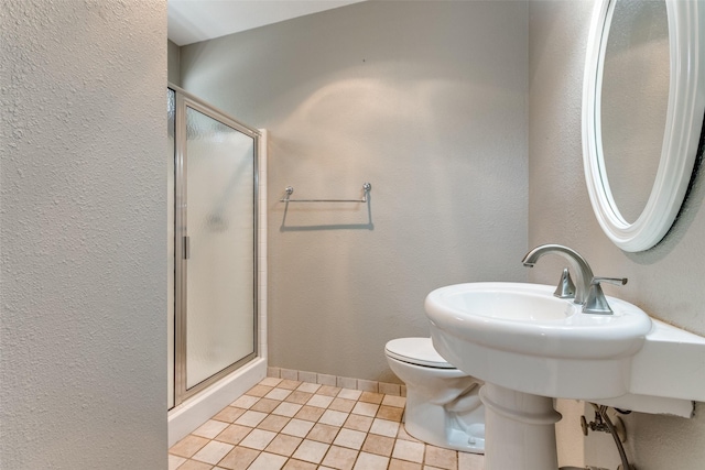 full bathroom with toilet, a shower stall, tile patterned flooring, baseboards, and a textured wall