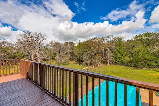 deck with a swimming pool and a yard